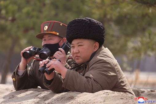 Kim Jong Un shuns coronavirus face mask and clutches binoculars as he watches missiles
