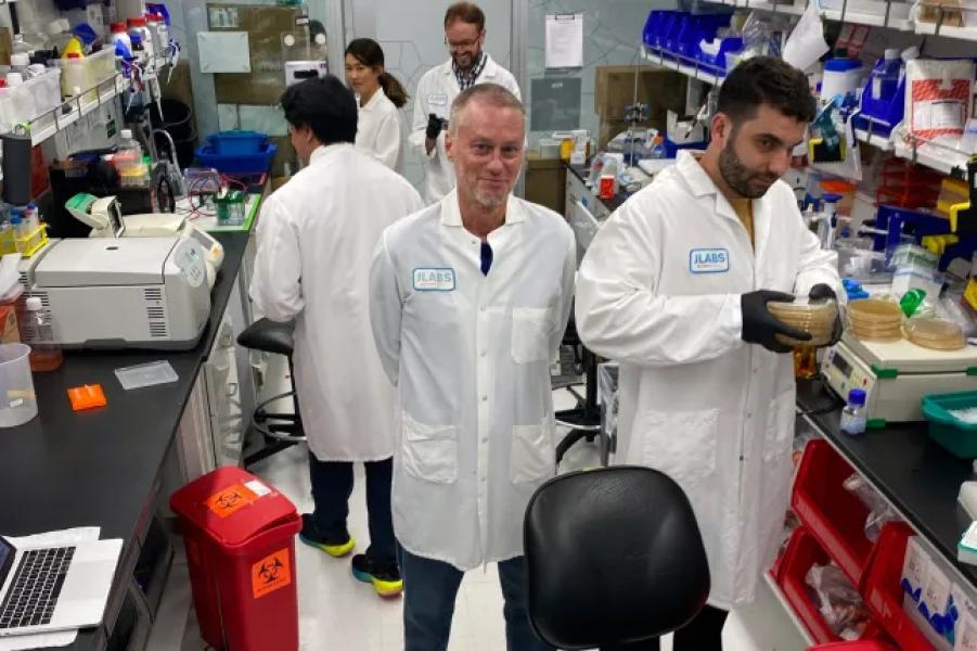 In this photo provided by Centivax, Tim Friede, center, stands in a lab in South San Francisco, California, in 2023, where his blood is used to prepare an antidote for various snake bites. (Centivax via AP)