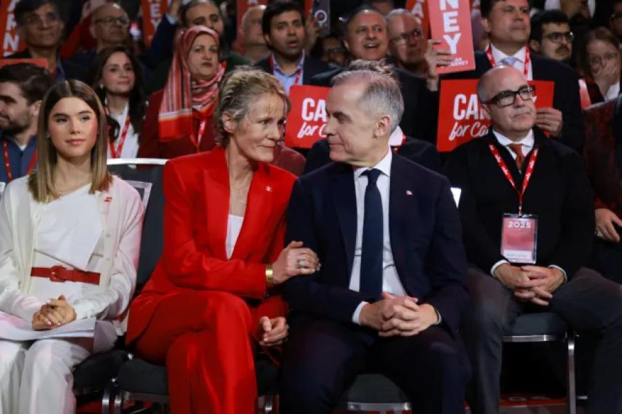 Mark Carney sits next to his wife Diane Fox as members of the Liberal Party of Canada meet to choose a successor to Prime Minister Justin Trudeau, in Ottawa, Ontario, Canada, March 9, 2025. REUTERS/Carlos Osorio/Pool