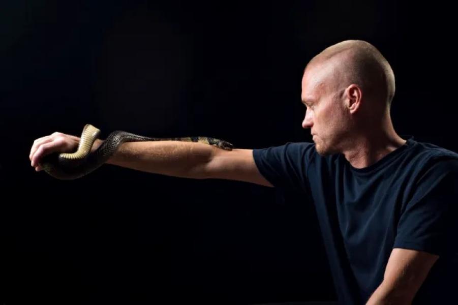 This undated photo provided by Centivax in 2025 shows Tim Friede, who is hyperimmune to the venom of various snakes, with a water cobra coiled around his arm. (Centivax via AP)