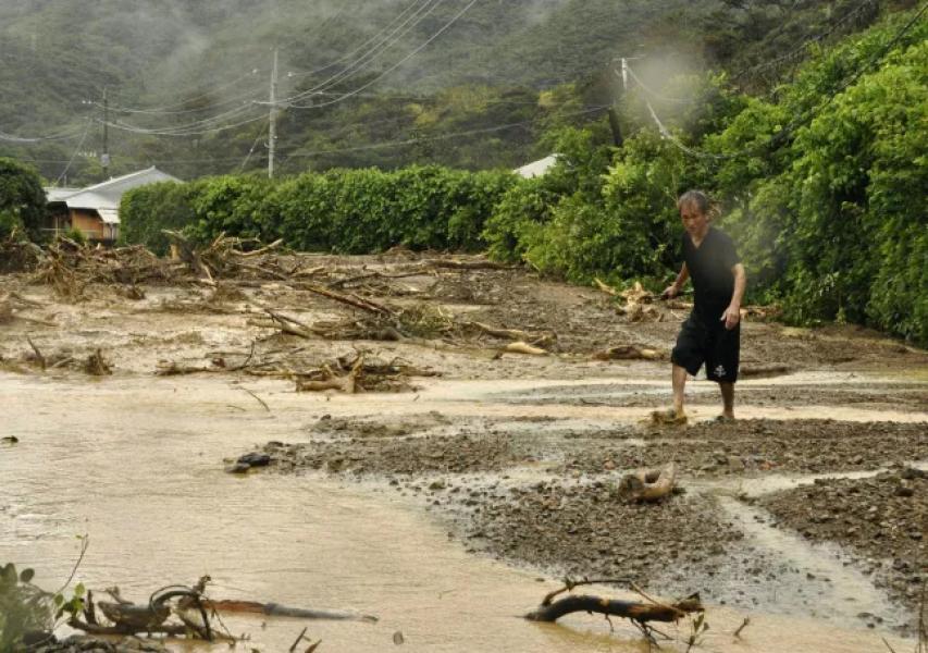 apan - A man walks on a road turned into mud by heavy rain in Tatsugo City on Amami Island, Kagoshima Prefecture, southwest Japan, September 26, 2011. (Kyodo)