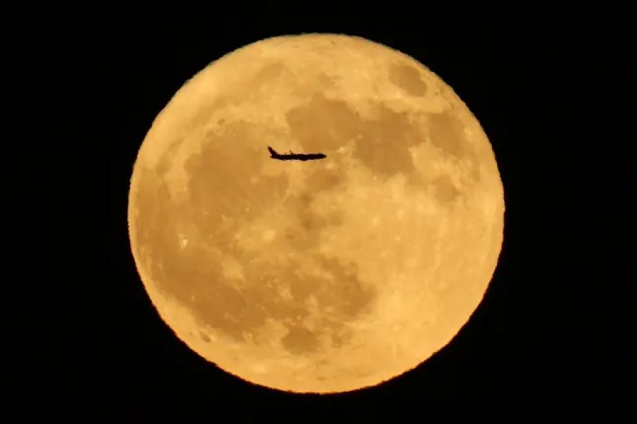 A plane is silhouetted as it crosses the full moon of Buck in Adelanto, California, July 10, 2025. (Photo by Patrick T. Fallon/AFP) (Photo by Patrick T. Fallon/AFP via Getty Images)