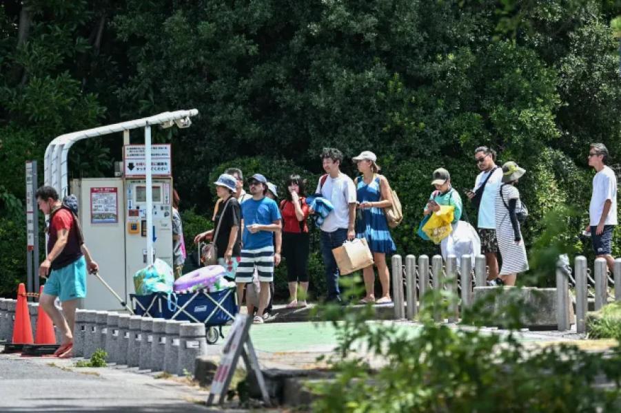 PHOTO - People line up to pay for parking as they leave the beach area of Inage Seaside Park after a tsunami warning was issued for much of Japan's coastline following an 8.7-magnitude earthquake off the coast of eastern Russia, along Tokyo Bay in Chiba City, Chiba Prefecture, July 30, 2025. A powerful 8.7-magnitude earthquake off the coast of Russia's Far East has triggered tsunami warnings in parts of the Pacific Ocean, including Japan, Hawaii, Russia and Ecuador, as well as along the coast of California, U.S. authorities said. (Photo by Philip FONG/AFP) (Photo by Philip FONG/AFP via Getty Images)