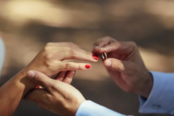 Close-up of the groom putting the wedding ring on the bride's finger