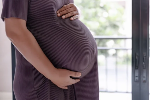 Close-up of a pregnant woman holding her belly. Concepts of pregnancy and well-being.